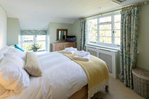 um quarto com uma grande cama branca e uma janela em Peaceful Riverside Five Bed Cottage in Somerset em Langport