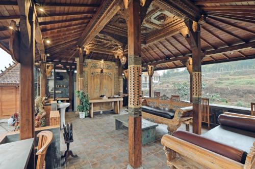 a large wooden pavilion with benches and a table at Tunjung Sari Villa Bedugul in Bedugul