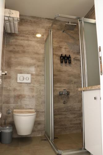 a bathroom with a shower and a toilet in it at TOROS DELUXE RESORT HOTEL in Yesilovacık