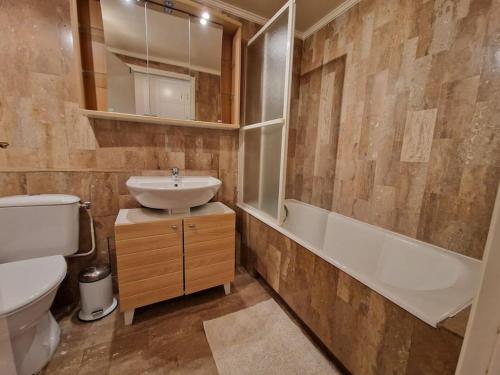 a bathroom with a sink and a toilet and a tub at Charmant studio Deauville, proche plage avec parking privé in Deauville