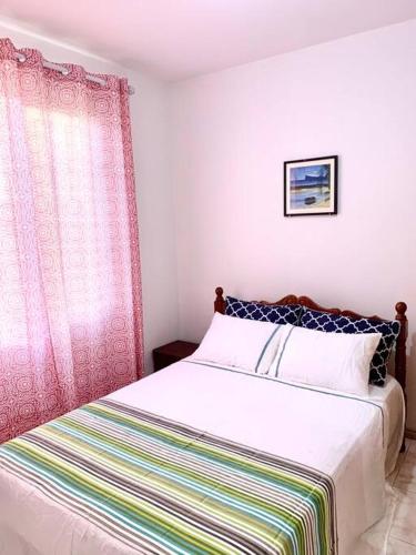 Un dormitorio con una cama con una manta de colores. en Ariel Beach Apartment, en Flic en Flac