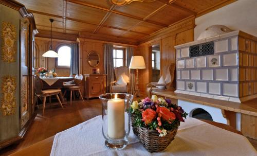 eine Kerze und Blumen auf einem Tisch in einem Zimmer in der Unterkunft Hotel Maier zum Kirschner in Rottach-Egern