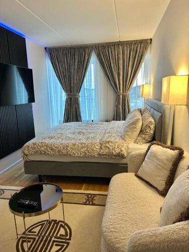 1 dormitorio con 2 camas y sofá en Attraktiv lejlighed en Odense