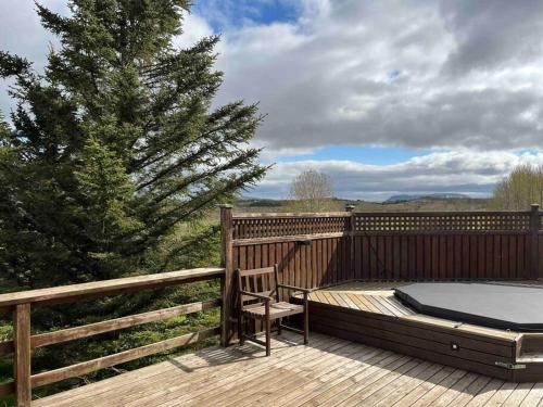 a wooden deck with a bed and a tree at Fell cottage in Reykholt