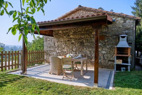 a patio with a table and a grill at Casa de Casal in Lestedo