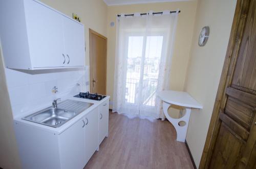 uma cozinha branca com um lavatório e uma janela em Antico Rione em Caltanissetta