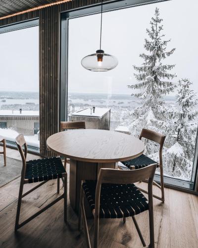 a dining room with a table and chairs and a christmas tree at Panorama Landscape Hotel in Nilsiä