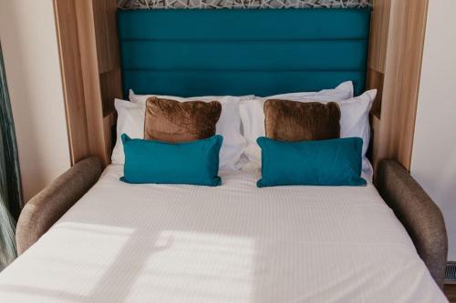 a large bed with two pillows and a blue headboard at Studio Pod 2 in Portland