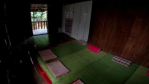 a room with a green floor with several mats on it at บ้านสวัสดีดอยเต่า 