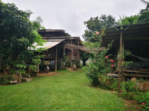 a garden with a house and a yard with grass at บ้านสวัสดีดอยเต่า 
