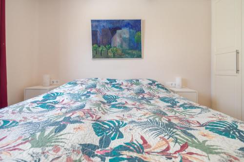 a bed with a colorful comforter in a bedroom at Lightbooking San Agustín next to the beaches in San Bartolomé de Tirajana