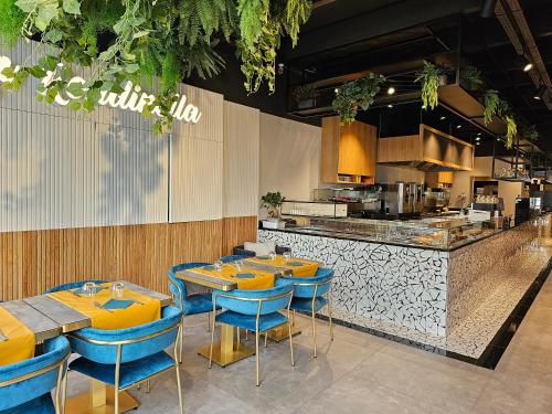 un restaurant avec des tables et des chaises bleues ainsi qu'une cuisine dans l'établissement Hotel Le Terminus, à Mons