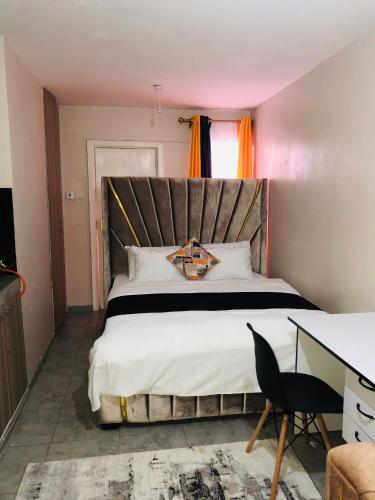 a bedroom with a large bed and a desk at Tsavo Embakasi in Nairobi