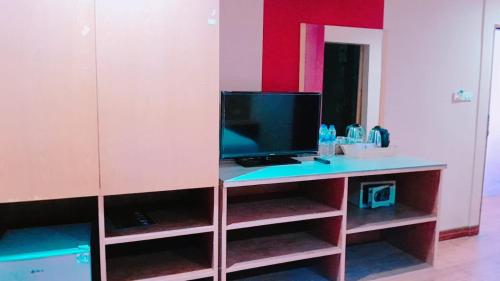 a room with a desk with a television on it at new pind balluchi inn in Pattaya
