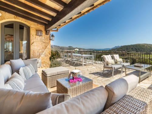 a patio with couches and a table and chairs at SundanceMallorca in Port de Pollensa