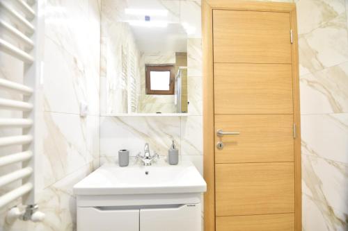 茲拉蒂博爾的住宿－Brvnara Mont 2，浴室设有白色水槽和镜子