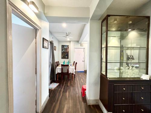 um corredor com um armário de vidro e uma sala de jantar em Lavish 2BHK Apartment in Ballygunge Place with Daily Housekeeping em Calcutá