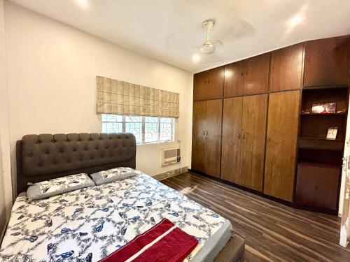 um quarto com uma cama grande e uma janela em Lavish 2BHK Apartment in Ballygunge Place with Daily Housekeeping em Calcutá