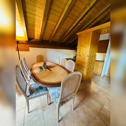 uma mesa de madeira e cadeiras num quarto em Deluxe Penthouse in the Swiss Alps em Val dʼIlliez