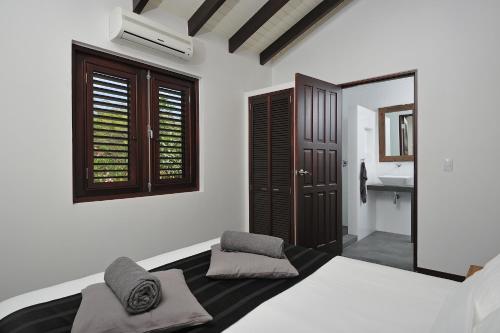a bedroom with a bed and a sink and a mirror at Bridanda boutique resort in Kralendijk