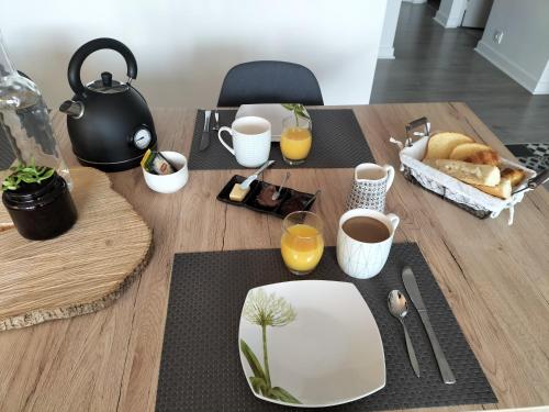 a wooden table with a tea pot and a table with food at Chambre chez l'habitant proche centre in Brest