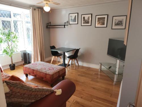 a living room with a table and a tv at Southernwood - West Wing in Didcot