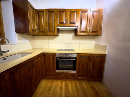 a kitchen with wooden cabinets and a stove top oven at Αρχοντικό Αλεξάνδρου in Kakopetria