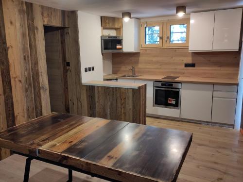 - une cuisine avec des murs en bois et une table en bois dans l'établissement Appartement chaleureux 2 chambres 4-6 pers, à Montgenèvre