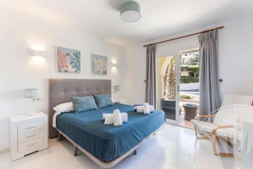 1 dormitorio con cama azul y balcón en La Manga Club - Los Olivos 604, en Atamaría