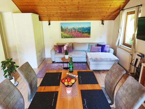 un soggiorno con tavolo, sedie e divano di Villa Bischofsberg - Lärchen-Wellness Apartment a Windischgarsten
