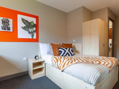 um quarto com uma cama com um edredão laranja e branco em For Students Only - Marvelous Private Ensuite Rooms at The Forge Sheffield em Sheffield