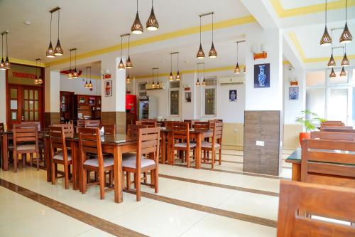 comedor con mesas y sillas de madera en Chelsea Hotel, en Dar es Salaam