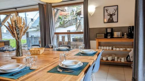 a dining room with a wooden table with blue napkins at Chalet Robin - spa- multipass- terrain de pétanque in Morzine
