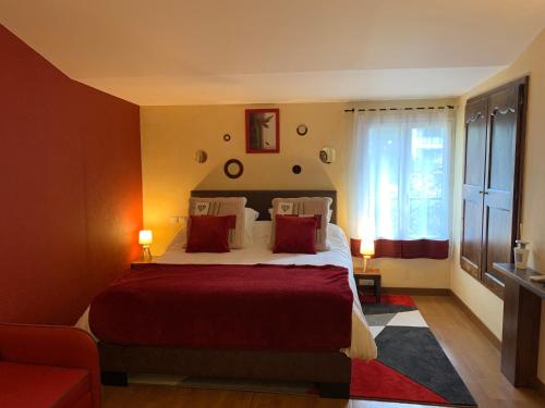 Un dormitorio con una cama con sábanas rojas y una ventana en Studio Au Clos Saint Georges , piscine et Spa, en Saint-Jory