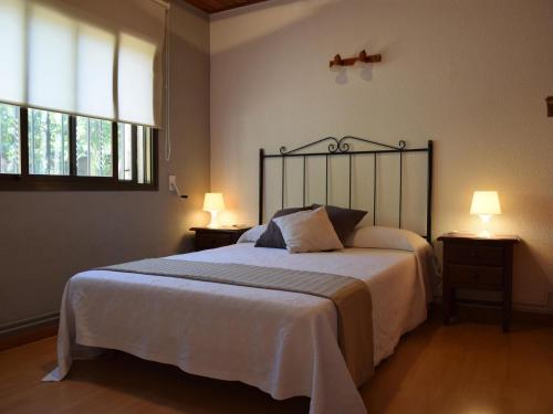 サン・フェリウ・デ・ギホルスにあるVilla pedraltaのベッドルーム1室(大型ベッド1台、窓2つ付)
