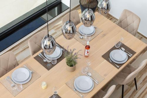 a wooden table with white plates and wine glasses at Villa GRC in Zaboric