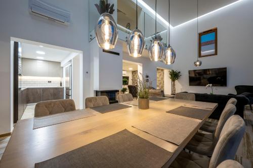 a dining room with a wooden table and chairs at Villa GRC in Zaboric
