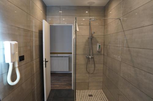 La salle de bains est pourvue d'une douche et d'un téléphone mural. dans l'établissement Hotel Montpensier, à Paris