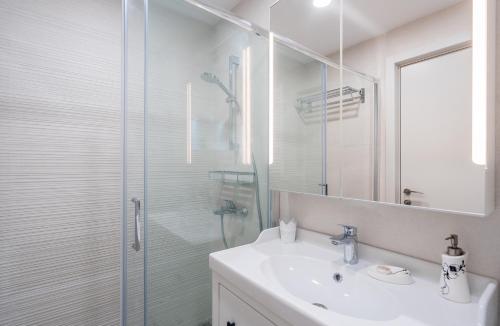 een badkamer met een wastafel en een glazen douche bij Lolo Apartment in Goedaoeri