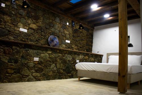 a bedroom with a stone wall with a bed at Αρχοντικό Αλεξάνδρου in Kakopetria