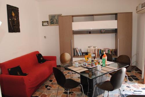 a living room with a red couch and a table at Calciufetta in Alghero