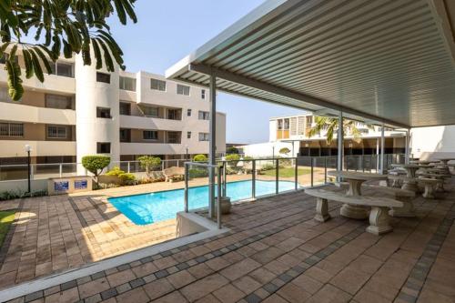 a pavilion with a picnic table and a pool at 201b Santorini in Margate