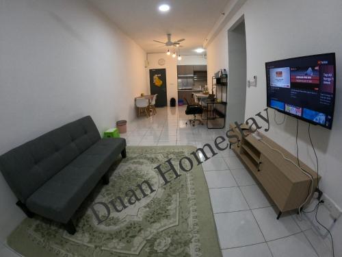 a living room with a couch and a flat screen tv at Duan Homestay @ Cybersouth (Muslim shj) in Kampung Dengkil