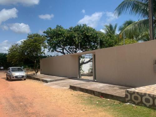 una casa con un coche aparcado delante de ella en Casa com piscina em Barra de Jacuípe BA, en Barra do Jacuípe