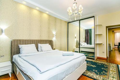 - une chambre avec un grand lit et un miroir dans l'établissement Apartment Malakan LUX, à Baku