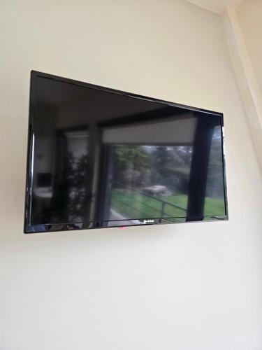 a flat screen tv hanging on a wall at Junção - Apartamentos Completos in Miranda do Douro