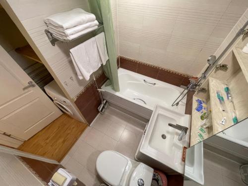 een badkamer met een wastafel, een toilet en een bad bij Two-Bedroom Apartment in Ulaanbaatar