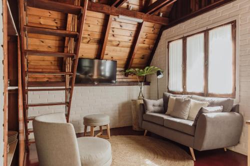 sala de estar con silla y TV en Overo Lodge & Selva en Puerto Iguazú