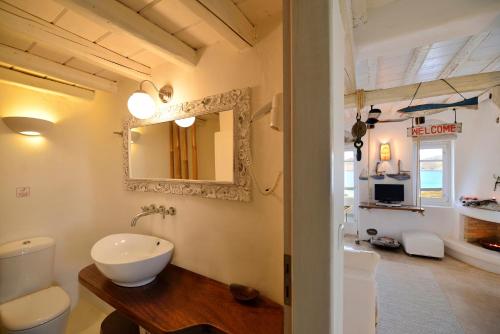 een badkamer met een wastafel en een spiegel aan de muur bij Villa Princess 5 4Bed with Jacuzzi Panormos Beach in Panormos Mykonos
