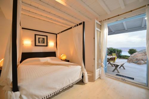 een slaapkamer met een bed en een groot raam bij Villa Princess 5 4Bed with Jacuzzi Panormos Beach in Panormos Mykonos